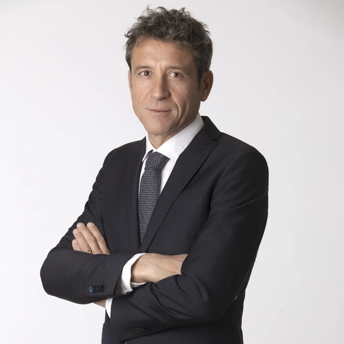 Ritratto professionale uomo in giacca e cravatta a braccia conserte, foto LinkedIn Milano