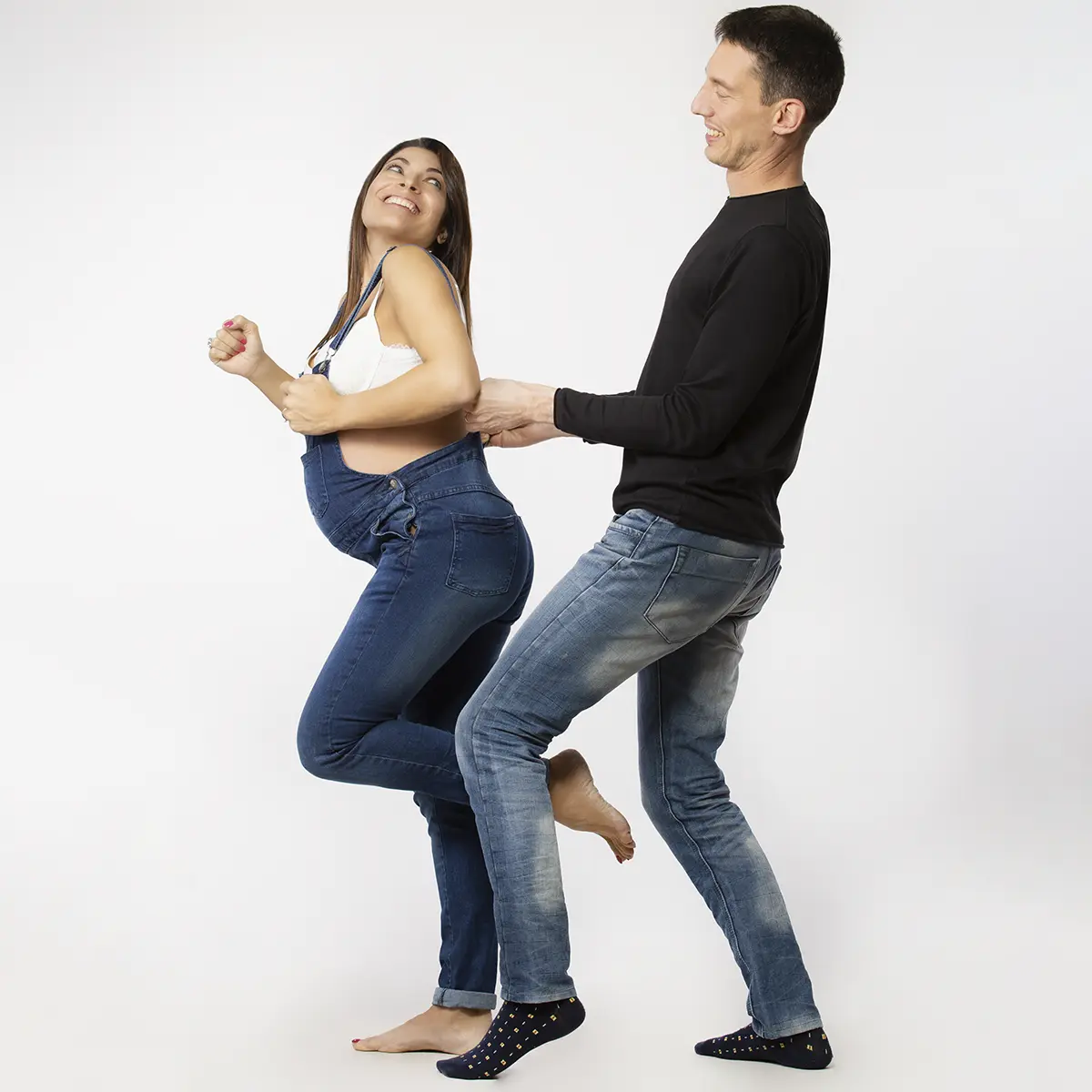 Coppia in attesa durante un book fotografico gravidanza a Milano, momento di complicità e risate in studio
