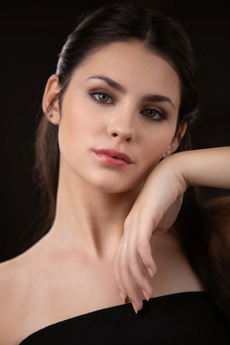 Ritratto beauty donna a Milano, primo piano su fondo scuro con trucco naturale